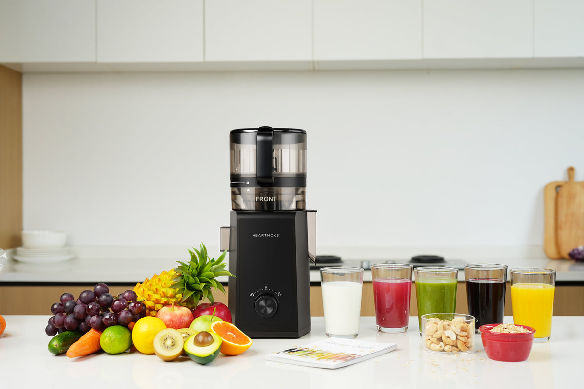 Heartnoks cold press juicer with fresh fruit, juice, nut milk, and sorbet in a bright kitchen